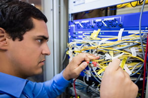 Close-Up of technician checking cables in a rack mounted server